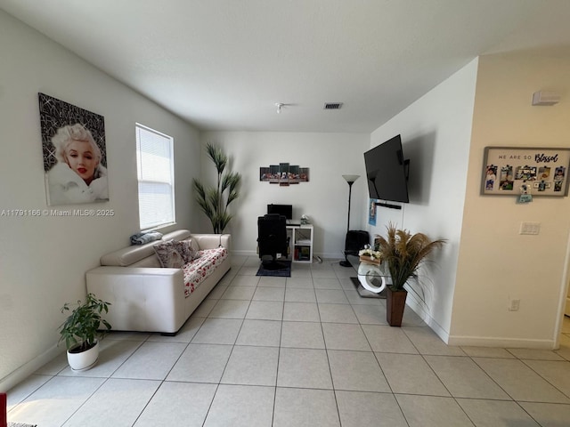 living area with light tile patterned floors, visible vents, and baseboards