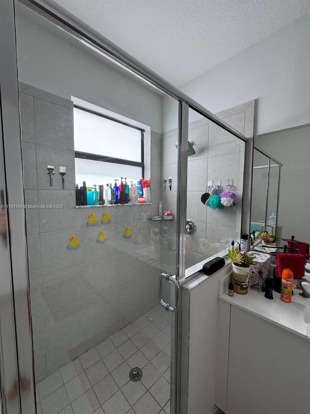 bathroom featuring tile patterned floors, a textured ceiling, and a shower stall
