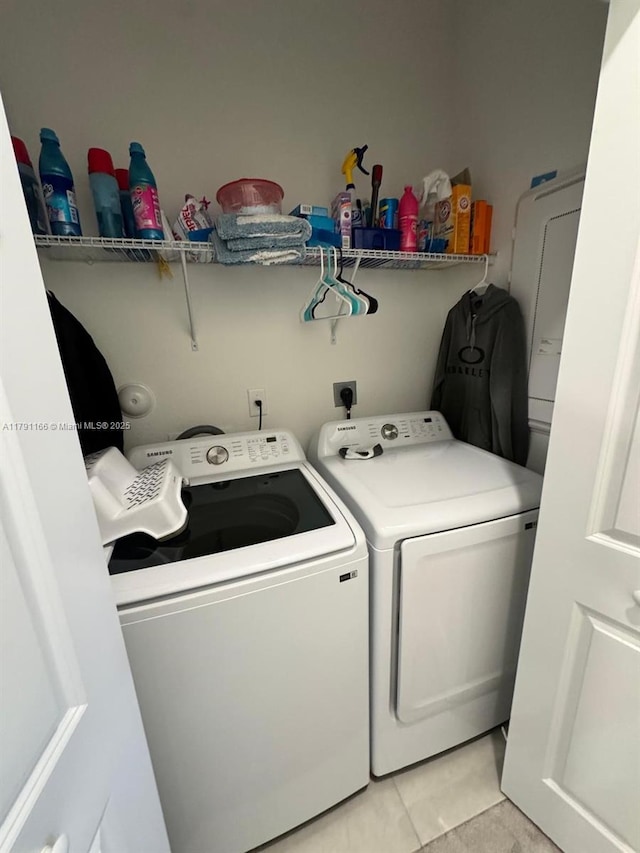 laundry room featuring light tile patterned floors, laundry area, and independent washer and dryer