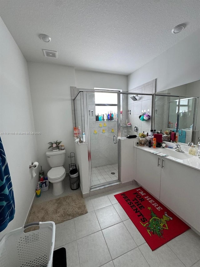full bathroom with vanity, toilet, a stall shower, visible vents, and a textured ceiling