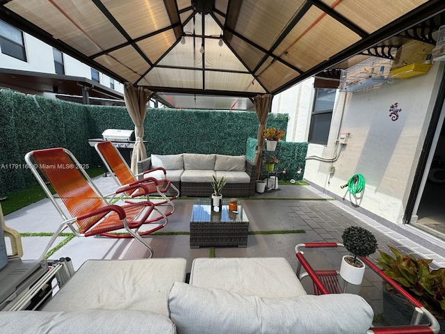 view of patio with outdoor dining space, a gazebo, an outdoor living space, and a fenced backyard