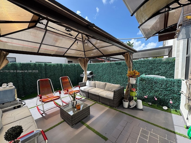 view of patio / terrace featuring an outdoor living space, a gazebo, and a fenced backyard