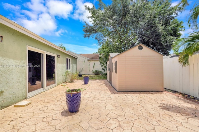 18982 Cloud Lake Cir, Boca Raton, FL 33496 - view of patio with fence, an outbuilding, and a storage unit