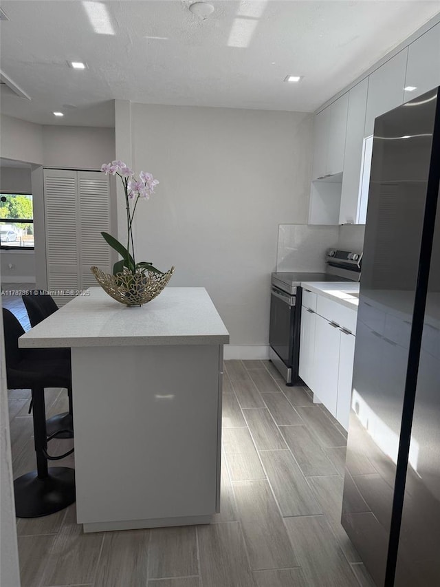 1710 E 6th Ave, Hialeah, FL 33010 - kitchen with stainless steel appliances, modern cabinets, a center island, a kitchen breakfast bar, and wood tiled floors
