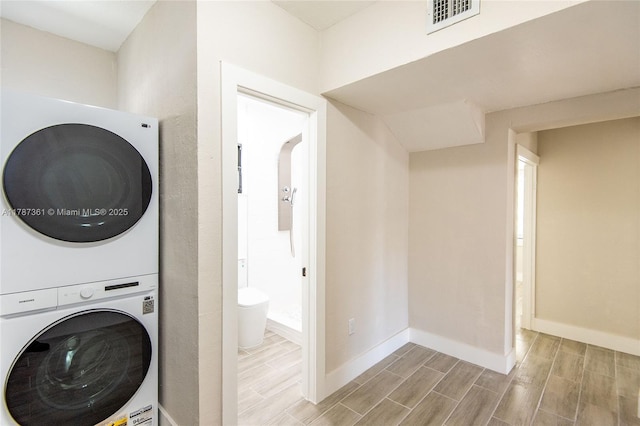1710 E 6th Ave, Hialeah, FL 33010 - washroom featuring stacked washer / dryer, wood finish floors, and baseboards