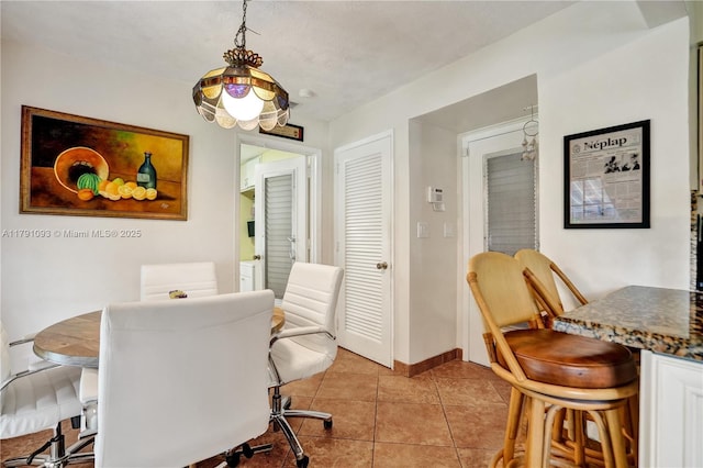 dining room with baseboards and light tile patterned floors