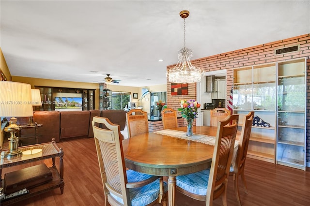 dining space featuring visible vents, brick wall, recessed lighting, wood finished floors, and ceiling fan with notable chandelier