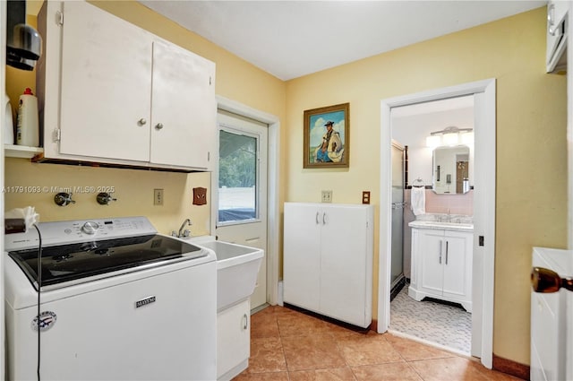 laundry room with light tile patterned floors, washer / dryer, cabinet space, and a sink