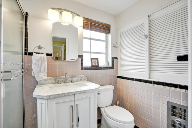 full bath featuring toilet, tile walls, a shower stall, and vanity
