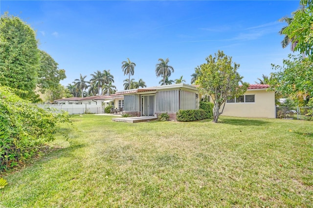 back of house with a lawn and fence
