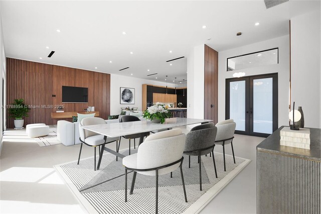 499 SW Squire Johns Ln, Palm City, FL 34990 - dining space with recessed lighting, wood walls, concrete flooring, an accent wall, and french doors