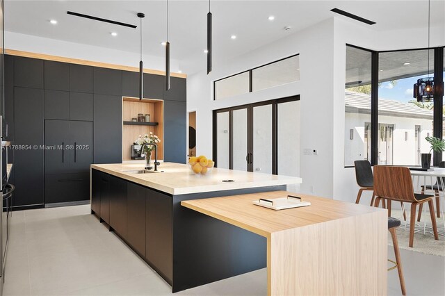 499 SW Squire Johns Ln, Palm City, FL 34990 - kitchen featuring modern cabinets, a kitchen island with sink, dark cabinets, pendant lighting, and recessed lighting