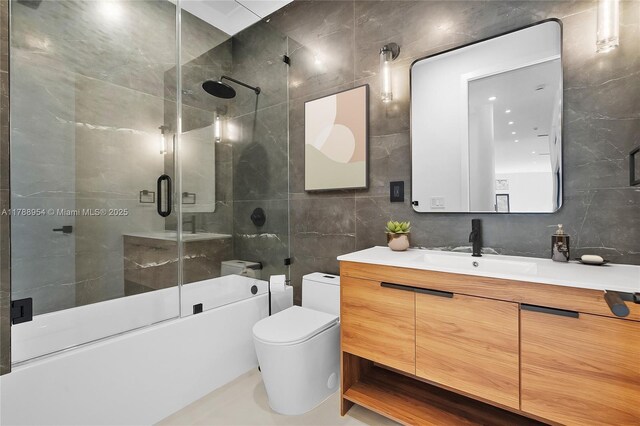 499 SW Squire Johns Ln, Palm City, FL 34990 - bathroom with tile walls, vanity, shower / bath combination with glass door, and backsplash