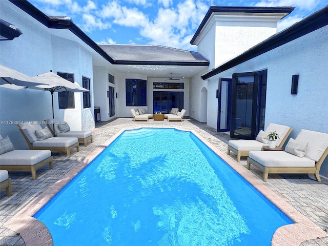 outdoor pool with a ceiling fan, a patio, and outdoor lounge area