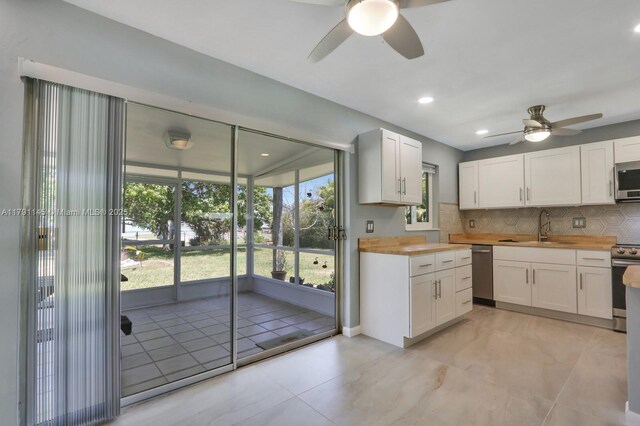 kitchen featuring wood counters, recessed lighting, white cabinetry, baseboards, and stainless steel refrigerator with ice dispenser
