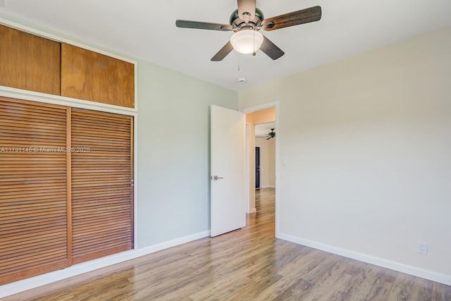 unfurnished bedroom with baseboards, a ceiling fan, light wood finished floors, and a closet