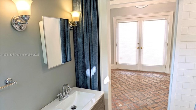 550 SW 13th Ave, Fort Lauderdale, FL 33312 - bathroom featuring brick patterned flooring, french doors, and vanity
