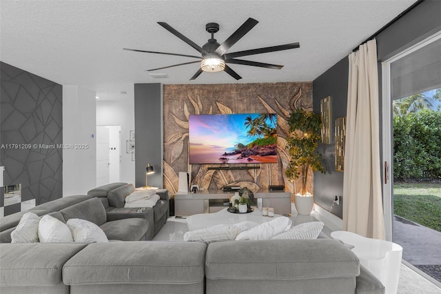 living room featuring a textured ceiling, ceiling fan, and an accent wall