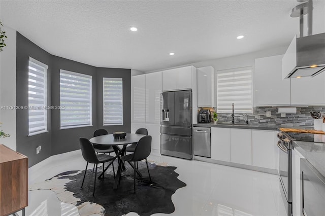 kitchen with stainless steel appliances, a sink, white cabinetry, and modern cabinets