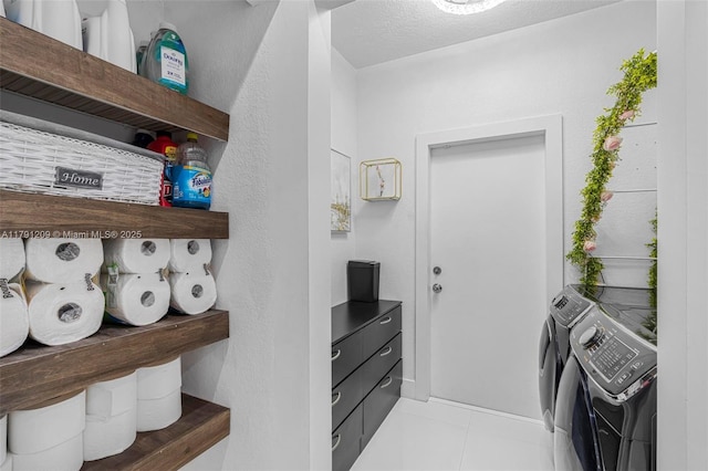clothes washing area featuring separate washer and dryer, tile patterned flooring, and laundry area