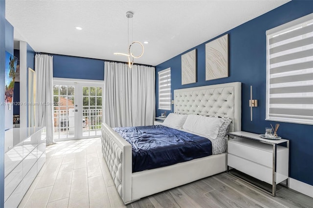 bedroom featuring a notable chandelier, access to exterior, french doors, recessed lighting, and wood finished floors