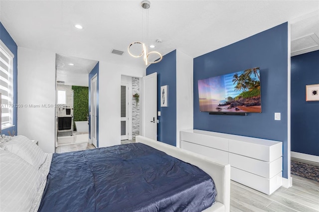 bedroom featuring visible vents, wood finished floors, baseboards, ensuite bathroom, and recessed lighting