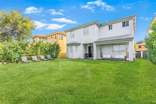 back of property with an outdoor hangout area, fence, stucco siding, and a lawn