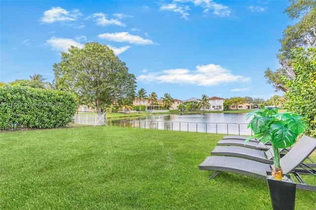view of yard with a water view, fence, and a residential view