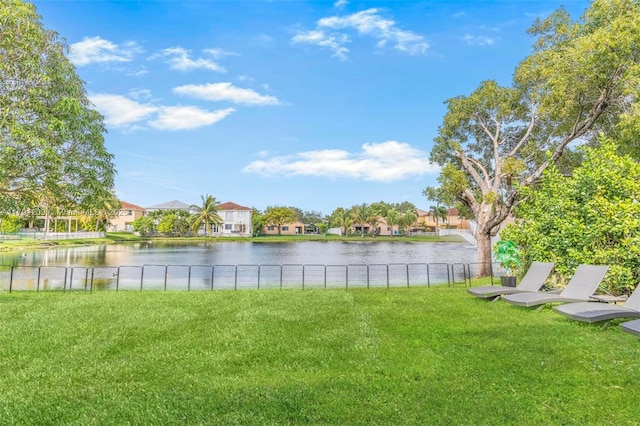view of yard with a water view, fence, and a residential view