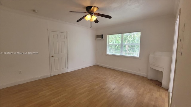 unfurnished bedroom featuring a wall mounted air conditioner, light wood-type flooring, crown molding, a ceiling fan, and baseboards