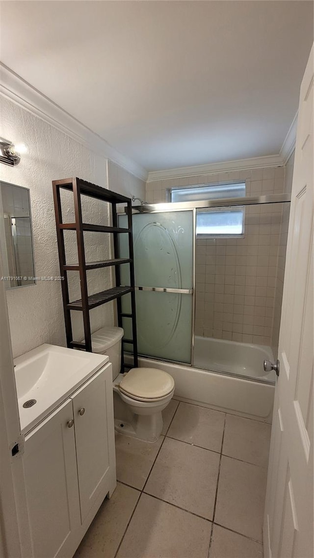 full bath with vanity, toilet, combined bath / shower with glass door, ornamental molding, and tile patterned flooring