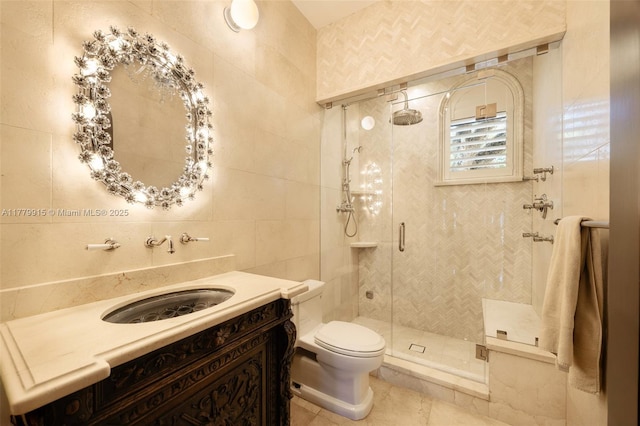 full bathroom featuring tile patterned flooring, tile walls, toilet, vanity, and a stall shower