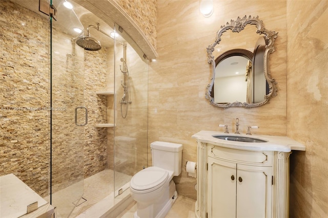 full bathroom with vanity, toilet, a shower stall, and tile walls