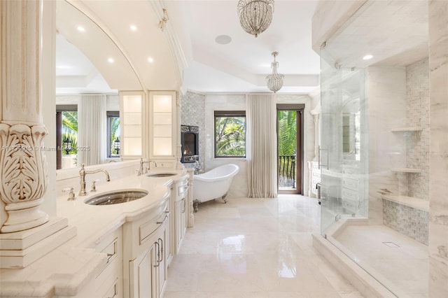 full bath featuring a freestanding bath, a sink, a shower stall, and a raised ceiling