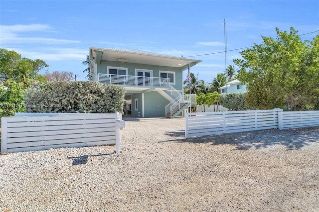 16 N Channel Dr, Key Largo, FL 33037 - back of property with stairway, a ceiling fan, fence, and a balcony