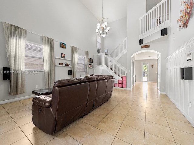 living room with arched walkways, high vaulted ceiling, and light tile patterned floors