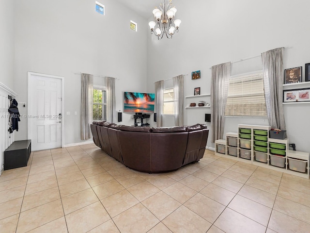 living room with light tile patterned floors, baseboards, a high ceiling, and a notable chandelier