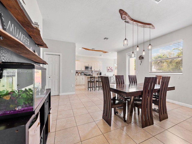 dining space with light tile patterned floors, baseboards, and visible vents