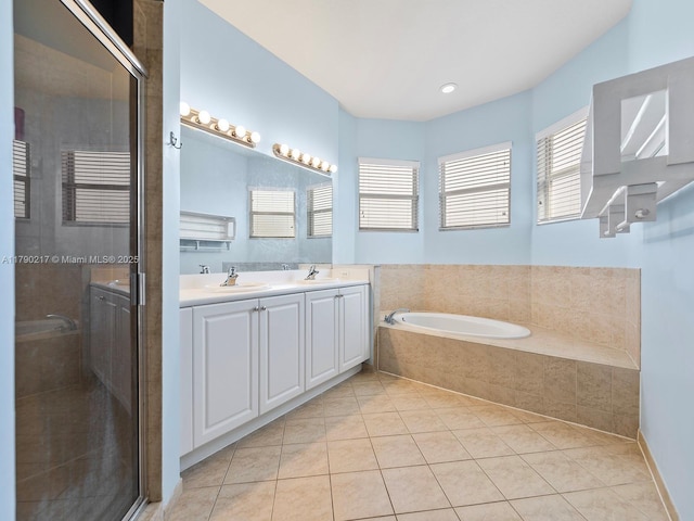 bathroom featuring tile patterned flooring, double vanity, a garden tub, and a shower stall