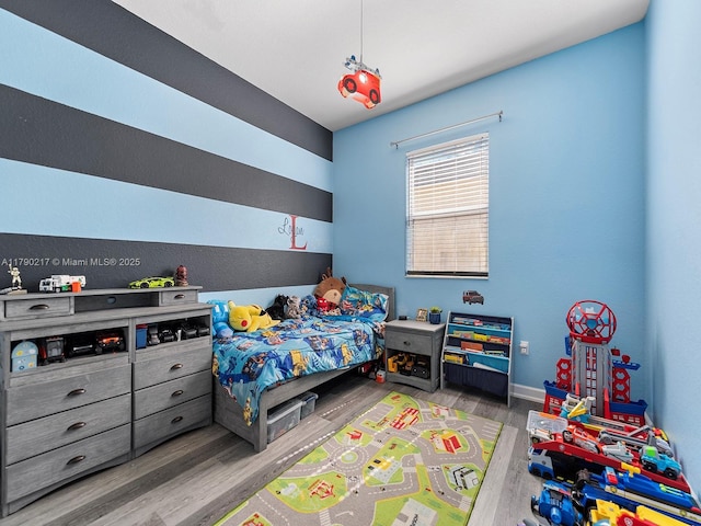 bedroom with baseboards and wood finished floors