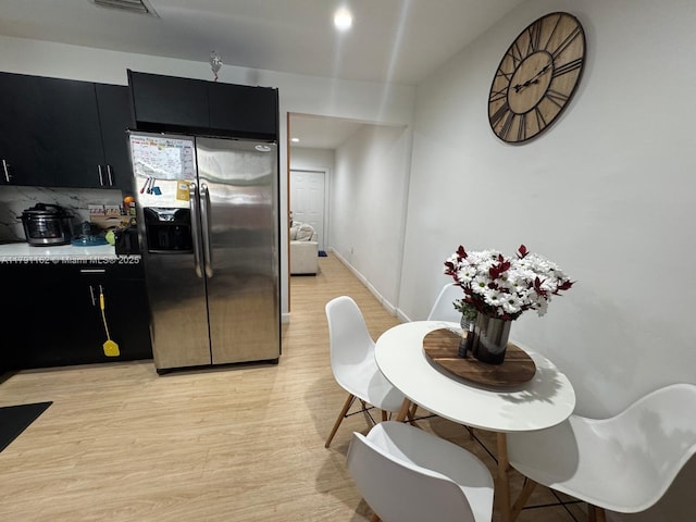 1855 NW 93rd St, Miami, FL 33147 - kitchen with dark cabinets, light wood-style flooring, stainless steel fridge, light countertops, and backsplash