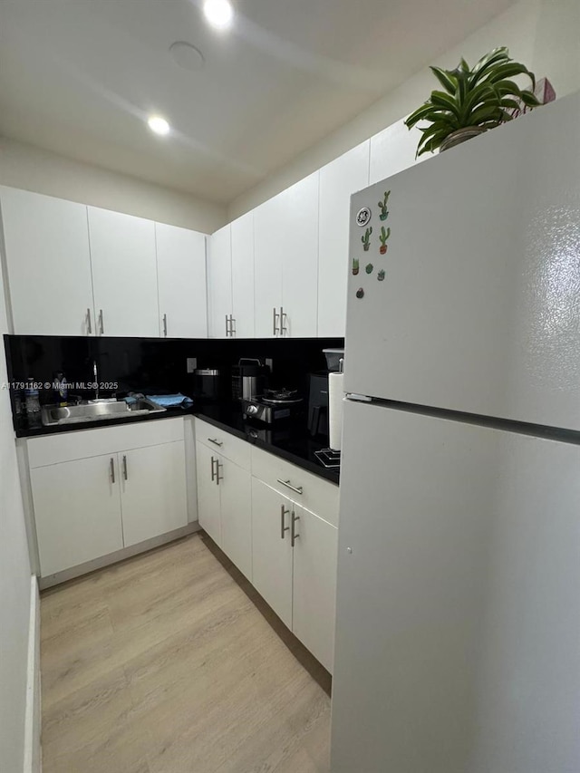 1855 NW 93rd St, Miami, FL 33147 - kitchen with a sink, light wood-style flooring, white cabinetry, dark countertops, and freestanding refrigerator