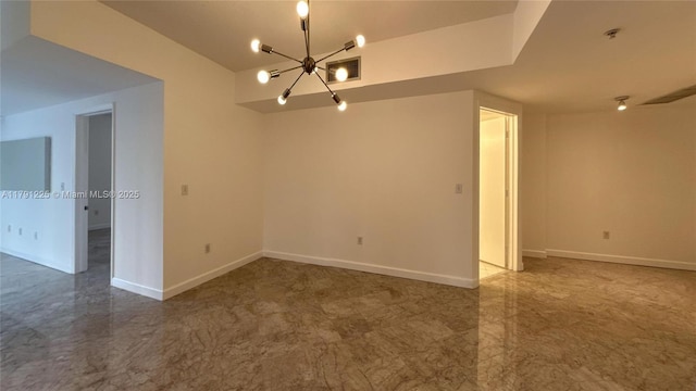 spare room featuring baseboards, visible vents, and a notable chandelier