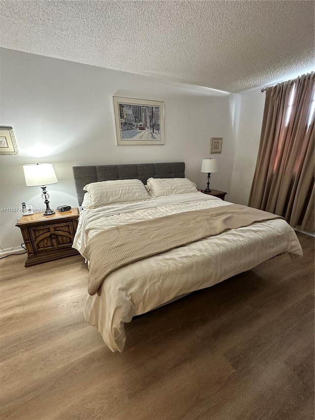 300 Bayview Dr Unit 315, Sunny Isles Beach, FL 33160 - bedroom with a textured ceiling and light wood-style flooring