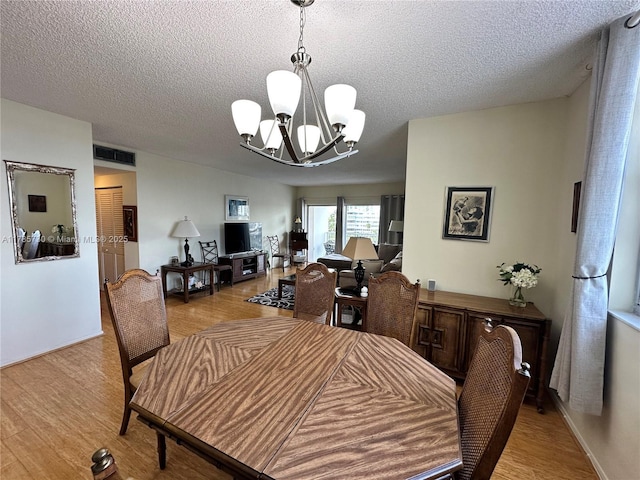 300 Bayview Dr Unit 315, Sunny Isles Beach, FL 33160 - dining space featuring a chandelier, a textured ceiling, and light wood finished floors