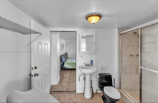 65890 Overseas Hwy, Long Key, FL 33001 - bathroom with a textured ceiling, a shower stall, a sink, ensuite bathroom, and tile patterned flooring