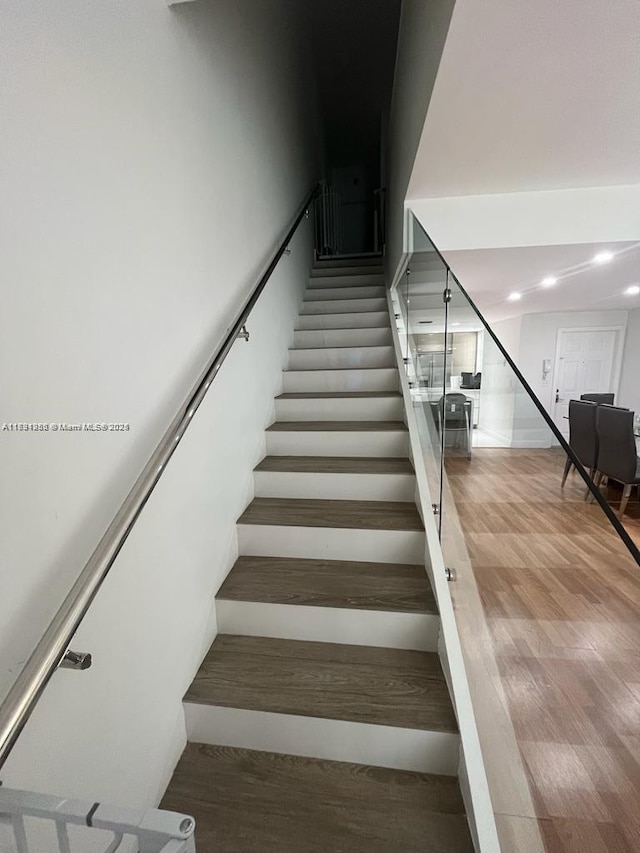 stairs featuring recessed lighting and wood finished floors