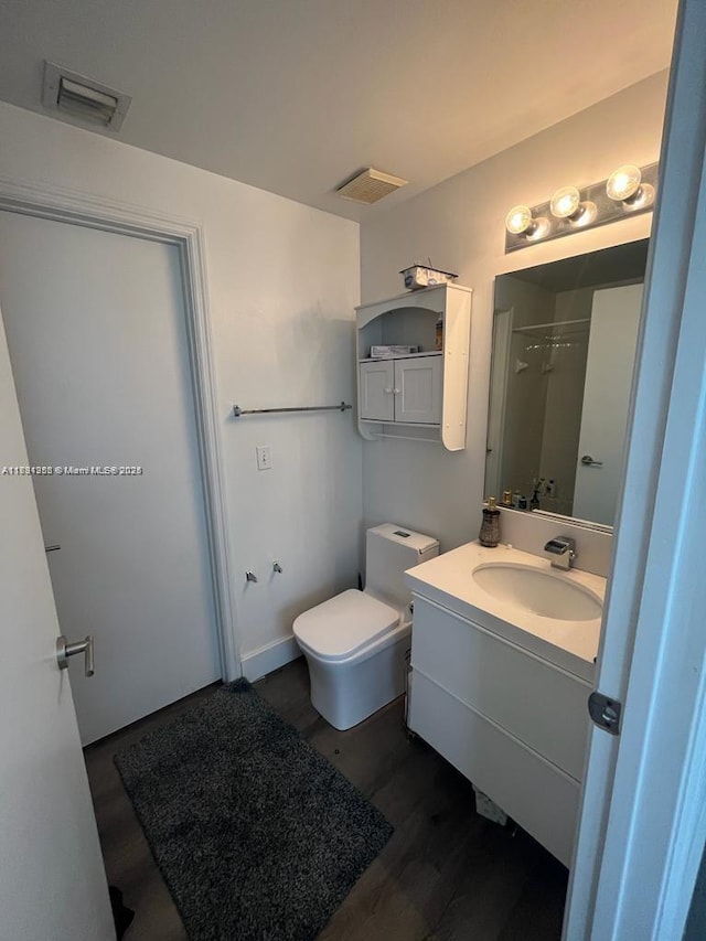 full bathroom featuring visible vents, wood finished floors, toilet, and vanity