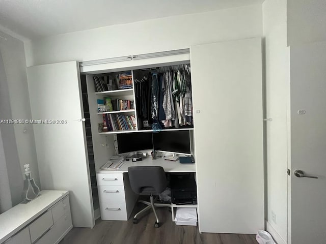 home office with built in desk and wood finished floors