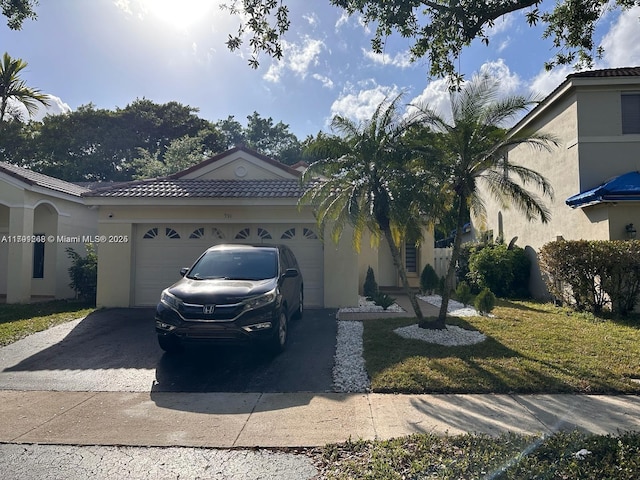 view of front of house with driveway, an attached garage, a tiled roof, and stucco siding